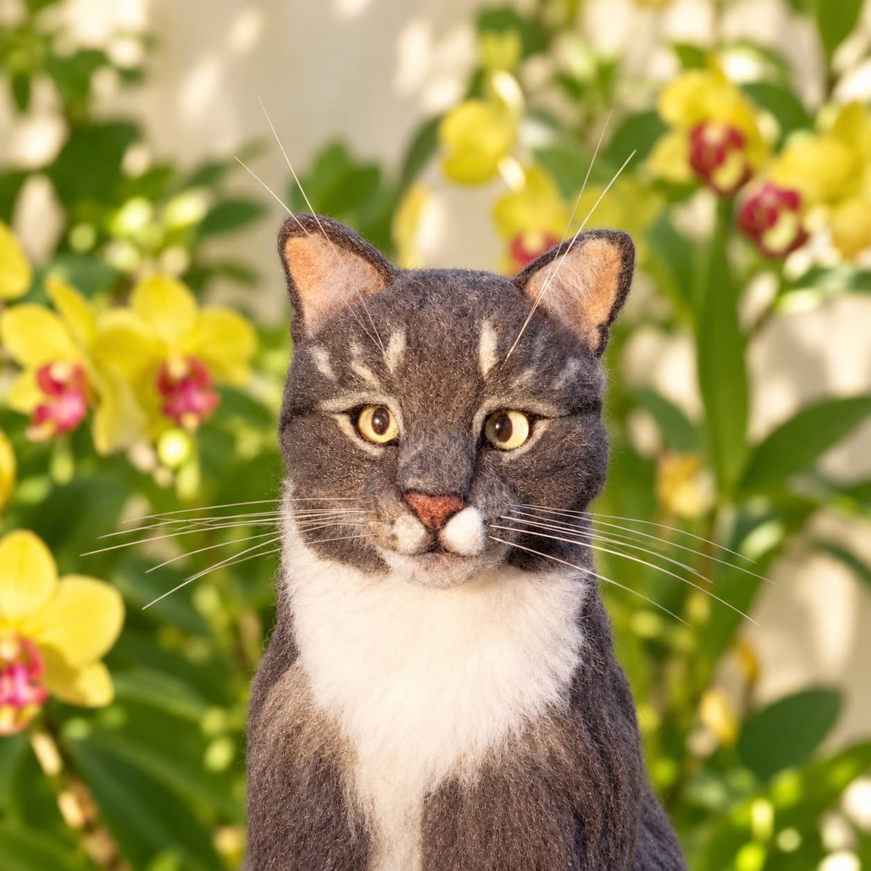 Gray tabby and white needle felted cat portrait with yellow eyes, close front view of the face and white chest