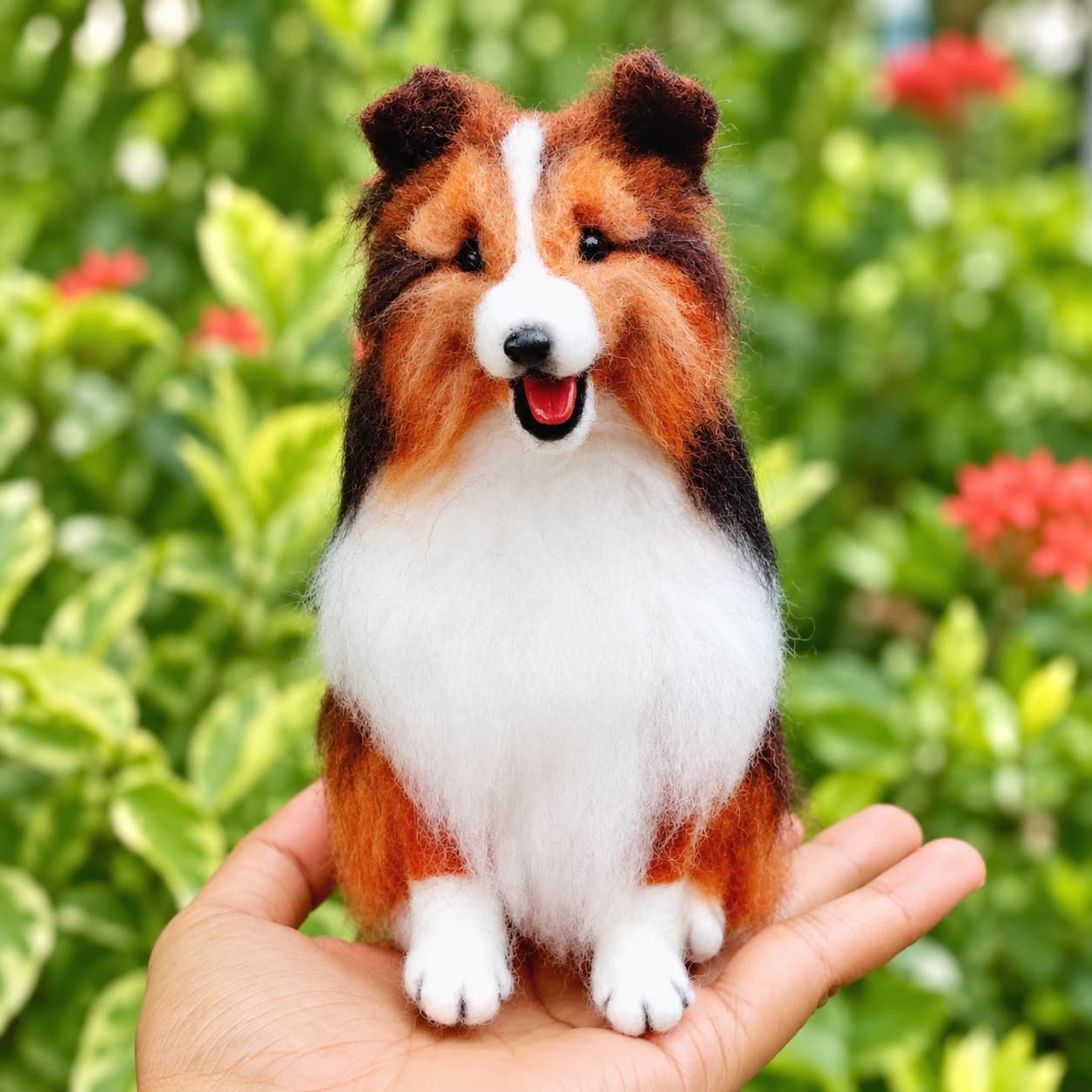 Sable and white mini Sheltie (Shetland Sheepdog) needle felted dog portrait, front view, sitting on an open hand