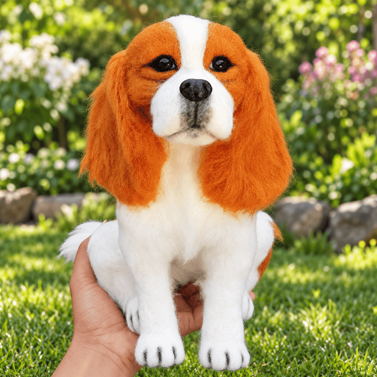 Blenheim Cavalier King Charles Spaniel (CKCS) puppy needle felted statue, front view, sitting in the hand outdoors